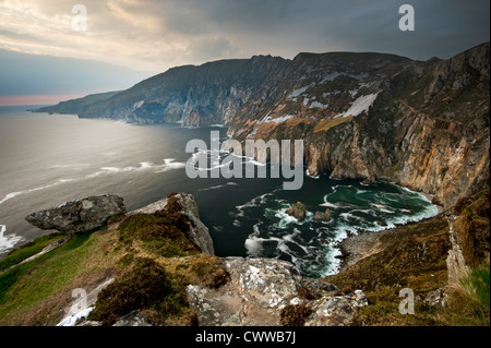 Le onde che si infrangono sulle scogliere rocciose Foto Stock