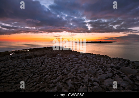 Tramonto sulla spiaggia di formazioni di roccia Foto Stock