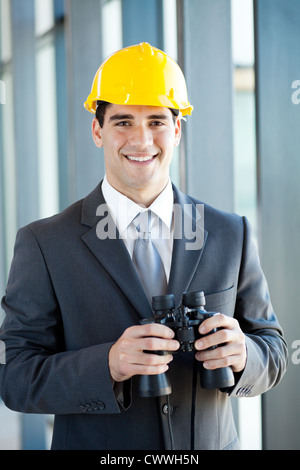 Bel giovane construction manager con il binocolo Foto Stock