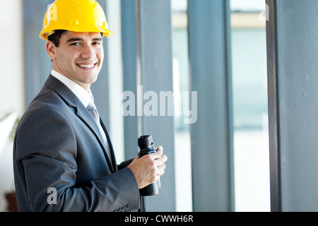 Felice giovane architetto maschio con il binocolo Foto Stock