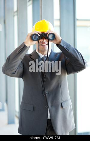 Giovane maschio construction manager utilizzando il binocolo Foto Stock