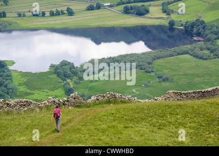 Un escursionista Alta discendente Hartsop Dodd con fratelli acqua nella distanza. Lake District. Foto Stock