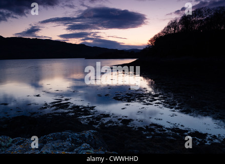 La marea si insinua in sopra Loch Sunart come il sole tramonta nel Nord Ovest Highlands della Scozia. Foto Stock