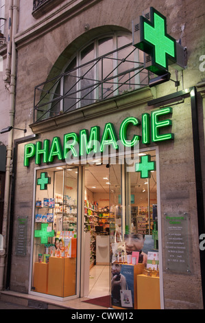 Le luci luminose e pulite il design clinica di un francese high street farmacia, con le sue verdi insegne al neon e crocette lampeggianti. Parigi, Francia. Foto Stock