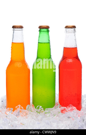 Dettaglio di tre diverse bottiglie di soda coperto di condensa in piedi in un letto di ghiaccio. Formato verticale su bianco. Foto Stock