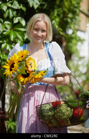 La donna a caccia di fiori e di ortaggi Foto Stock