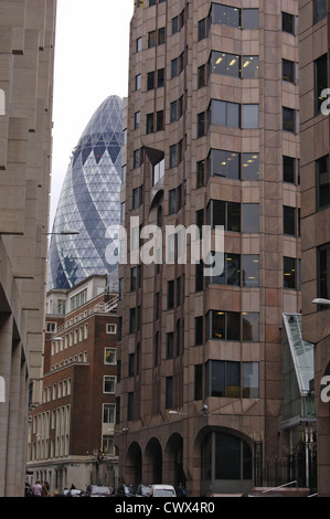 Il Gherkin torre di uffici attraverso una strada stretta nella City di Londra, Inghilterra Foto Stock