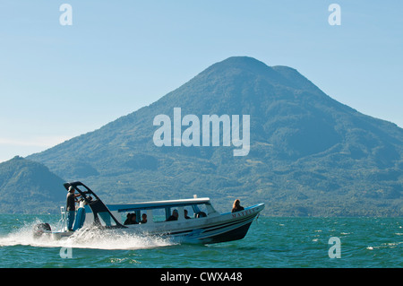 Un acqua taxi motoscafo sul Lago de Atitlan, lago Atitlan, con vulcano Toliman e San Juan la Laguna, Guatemala. Foto Stock