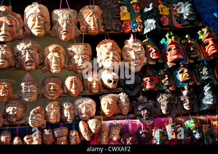 Legno intagliato maschera maschere fornitore nel mercato locale, Chichicastenango, Guatemala. Foto Stock