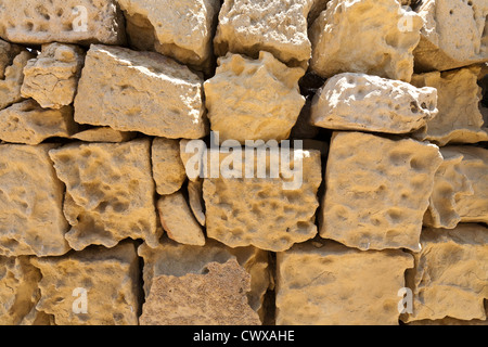 Close up di arenaria gialla blocchi di parete fortemente alterate dal vento e dalla pioggia l'erosione Foto Stock