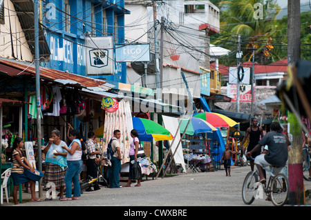 La folla di persone sulla strada principale nel centro di Livingston un Garifuna città africana sul lago Izabal, Lago de Izabal, Guatemala. Foto Stock