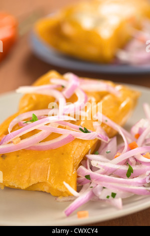 Tamales peruviana (tradizionalmente mangiato per la prima colazione di Domenica) fatta di mais e pollo e servito con salsa criolla Foto Stock