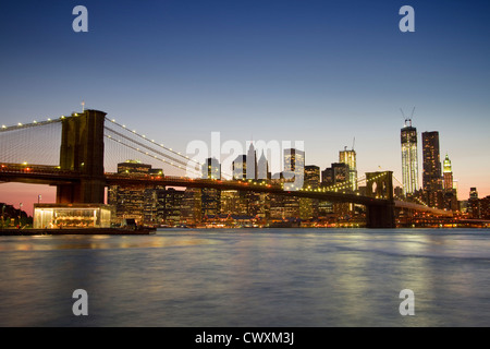 Una vista al tramonto del Ponte di Brooklyn e la skyline di Manhattan dietro Foto Stock