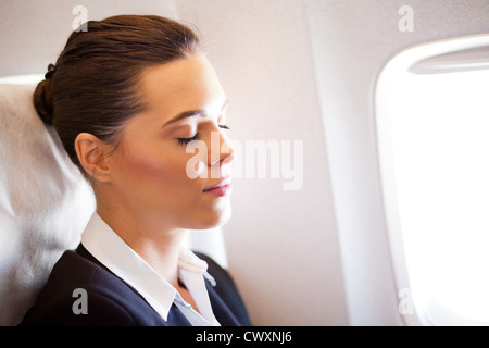 Bella giovane imprenditrice in appoggio su aereo Foto Stock