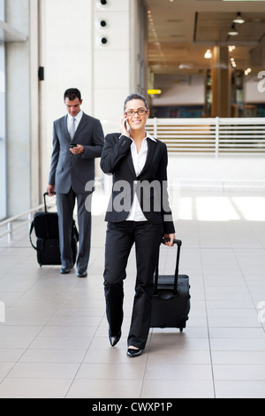 Gli imprenditori a piedi in aeroporto con i bagagli Foto Stock