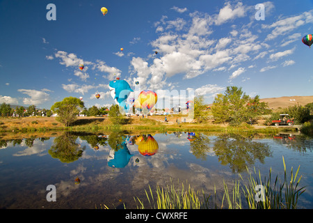 Palloncini ad aria calda che si riflettono su un grande stagno a Reno, Nevada. La caramella dell'occhio è l'unico senso descrivere i palloncini dell'aria calda. Foto Stock