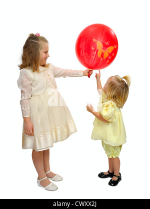 Ragazze in abiti a fantasia giocare con un palloncino rosso. Foto Stock