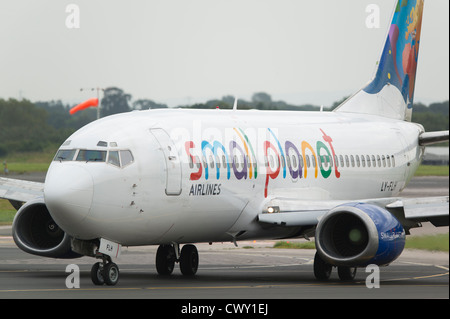 Un lituana Small Planet Airlines Boeing 737 di rullaggio sulla pista dell'Aeroporto Internazionale di Manchester (solo uso editoriale) Foto Stock