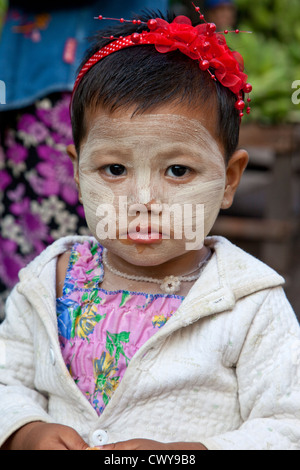 Myanmar Birmania, Mandalay. Piccola ragazza birmano con Thanaka incollare sul suo volto, un cosmetico Sunscreen. Foto Stock