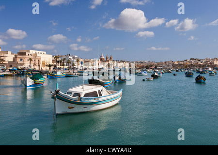 Le barche nel porto presso il più grande villaggio di pescatori sull'isola di Malta, la Baia di Marsaxlokk, Mare Mediterraneo. Foto Stock