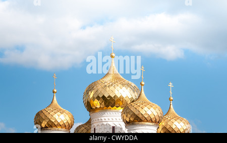 Splendido edificio storico. Golden round cupole e torri bianche della chiesa ortodossa. Luminoso cielo blu con nuvole bianche Foto Stock