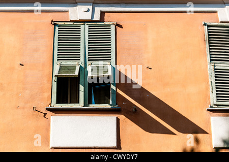 Bella e antica finestra chiusa. Vecchia casa gialla e blu cielo in background. Cote d Azur, Nizza, Francia, Europa. Foto Stock
