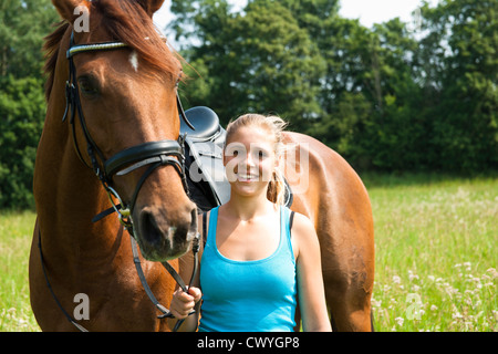 Ragazza adolescente a cavallo sul prato Foto Stock