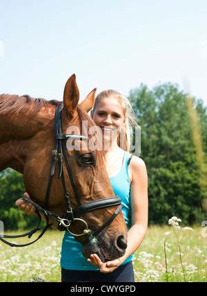 Ragazza adolescente a cavallo sul prato Foto Stock