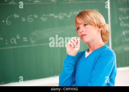 Scolaro a blackboard pensando di formula Foto Stock