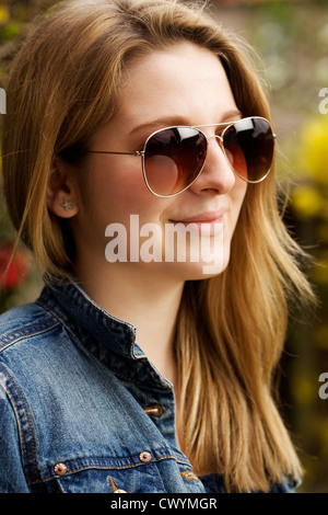 Una immagine di moda di un teenage una ragazza indossando aviatori. Foto Stock