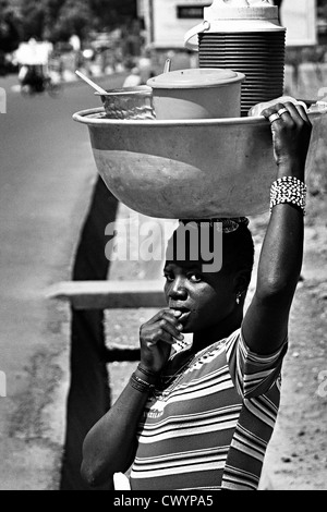 Cucina di strada venditore portando i suoi prodotti sul suo capo . Benin Foto Stock
