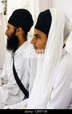 La religione sikh giovane vestito di bianco ad Amritsar Golden Temple , India Foto Stock