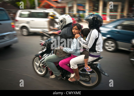 Famiglia di 4 su un ciclomotore in Legian la strada principale di Legian, meridionale di Bali, Indonesia. Foto Stock