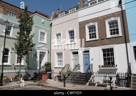 Il abbastanza bello colorate case a schiera su Bywater Street, appena fuori la Kings Road nel quartiere di Chelsea, West London,SW3, Regno Unito. Foto Stock
