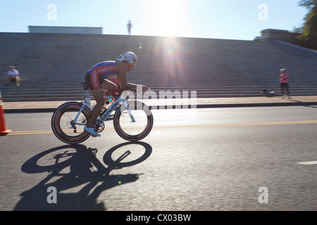 Ciclista racing in condizioni di intensa luce solare Foto Stock