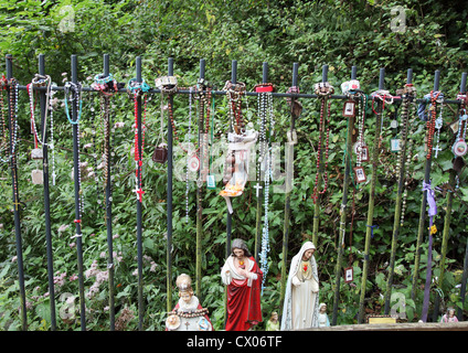 I grani del Rosario ed altre religiose elementi formano un piccolo santuario di San Winefride ben, Holywell, il Galles del Nord Foto Stock