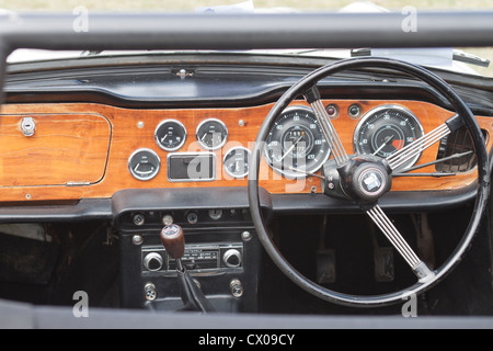 Il cockpit, ruota e il cruscotto di un auto classica Foto Stock