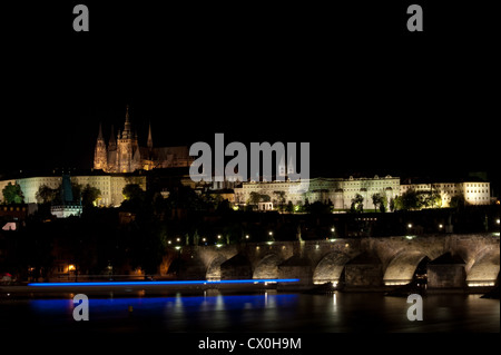 Luci di un Riverboat passando la notte con il Castello di Praga in background Praga, Repubblica Ceca Foto Stock