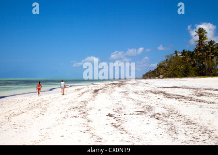 La gente che camminava su una spiaggia deserta di sabbia bianca, Bwejuu, Zanzibar africa Foto Stock