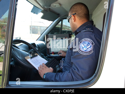 Officer aziona un mobile X-ray van scansioni diversi veicoli diretti verso il Messico per possibili armi nascoste a Laredo, Texas Foto Stock