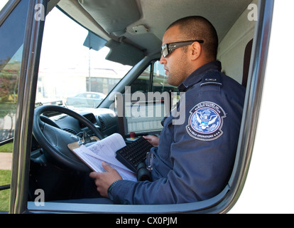 Officer aziona un mobile X-ray van scansioni diversi veicoli diretti verso il Messico per possibili armi nascoste a Laredo, Texas Foto Stock