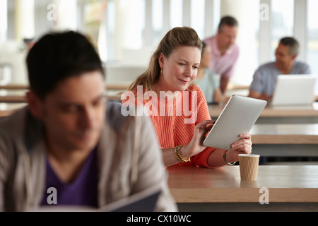 Donna con tavoletta digitale in classe Foto Stock