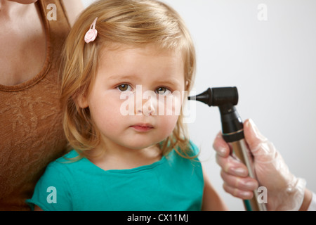 Bambina avente il suo orecchio controllato Foto Stock