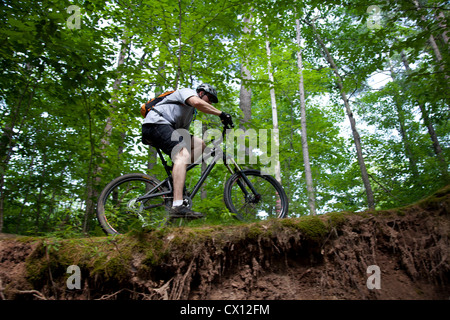 Uomo in mountain bike sulla mensola Foto Stock