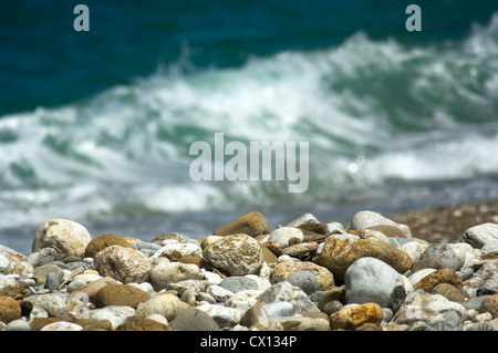 Close-up di una spiaggia di ciottoli con onde in background Foto Stock