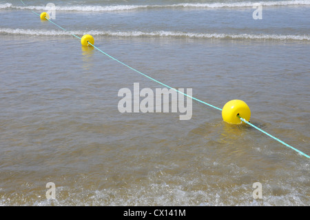 Galleggianti di colore giallo, blu di corda, galleggiante sul mare poco profondo, le onde che si infrangono, Costa de la Luz. Foto Stock