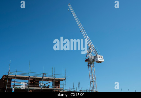 Una gru bianca contro un cielo blu su un cantiere nel centro di Birmingham, Regno Unito Foto Stock