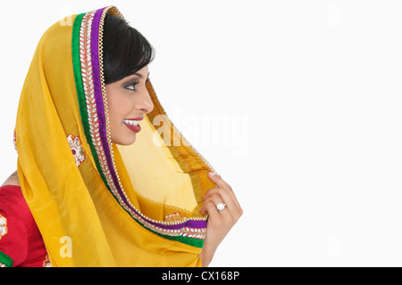 Vista laterale della femmina indiano holding dupatta su sfondo bianco Foto Stock