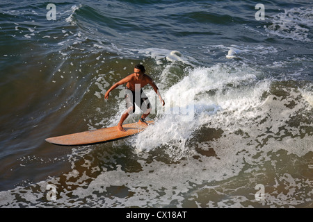 Locale longboard giavanese surfer surf un ondata di Batu Karas, West Java, Indonesia. Foto Stock