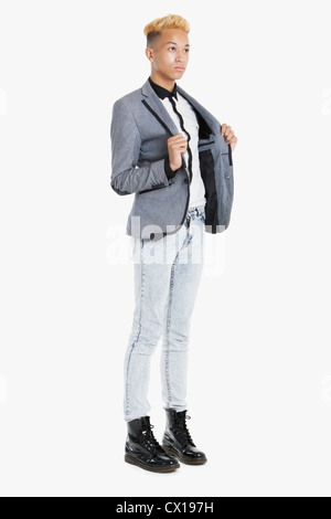 Ragazzo adolescente in smart casuals su sfondo grigio Foto Stock